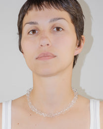 Model wearing bold glass chain necklace with thick borosilicate links, minimal handmade design, and sterling silver clasp.