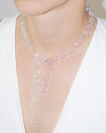 Model wearing bold transparent and pink glass chain necklace with two drop details, handmade borosilicate links and sterling silver clasp.