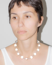 Model wearing transparent Orb Necklace, handmade solid borosilicate glass spheres linked in a continuous glass chain.