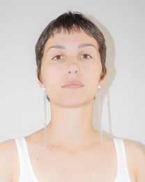 Model wearing Thin Chain Earrings, extra-long chain style handmade from borosilicate glass with orb top detail and sterling silver studs.