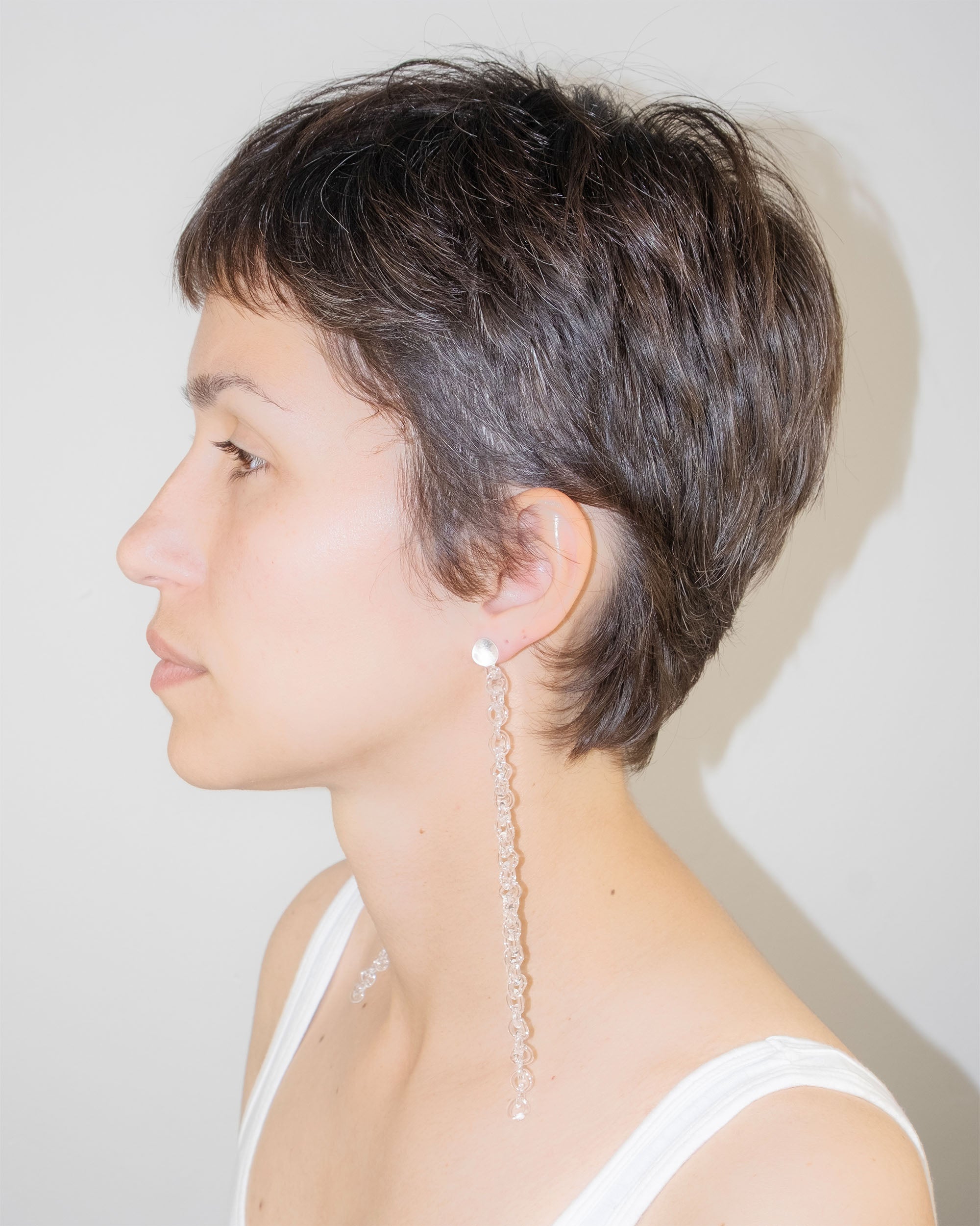 Model wearing Thin Chain Earrings, extra-long chain style handmade from borosilicate glass with orb top detail and sterling silver studs.