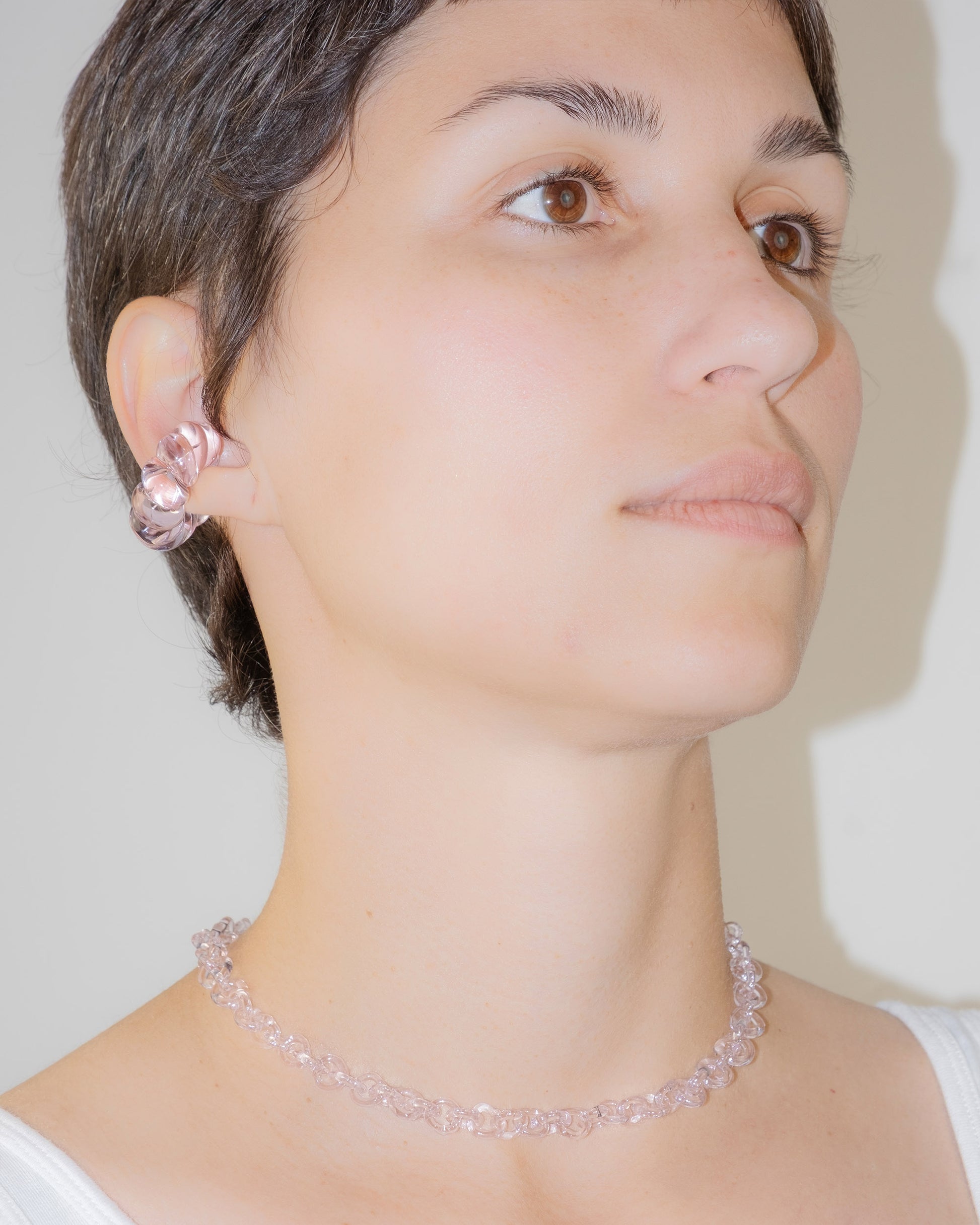 Model wearing handmade thin borosilicate necklace in pink with sterling silver clasp.