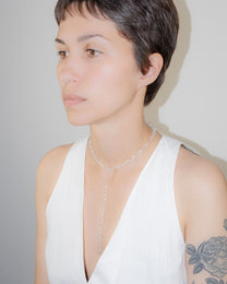 Model wearing thin transparent glass chain necklace with extended drop, styled elegantly, handmade borosilicate links with sterling silver clasp.