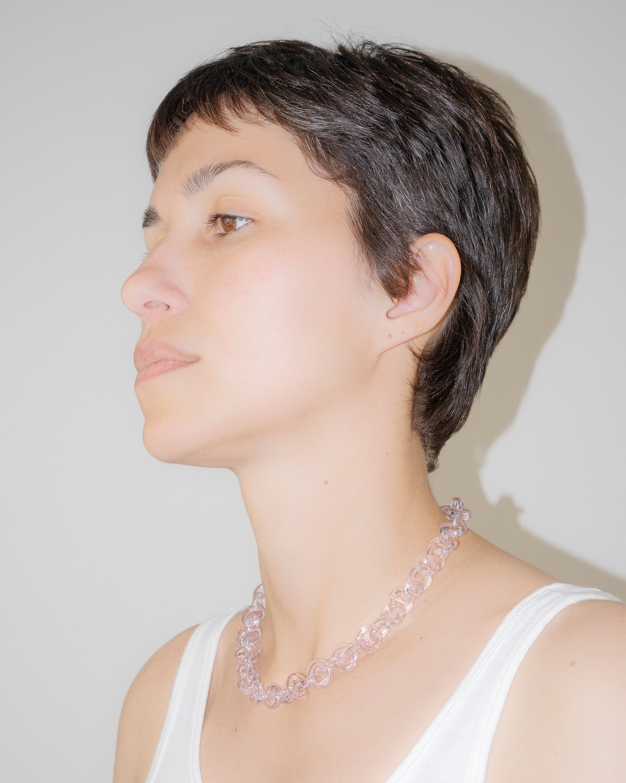Model wearing bold glass chain necklace in pink, handmade borosilicate links with minimal, timeless design.