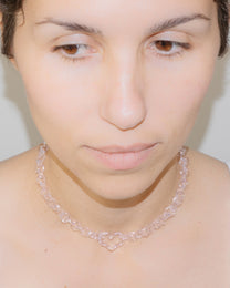 Model wearing pink thin glass chain necklace with central glass heart, handmade borosilicate jewelry, adjustable design.