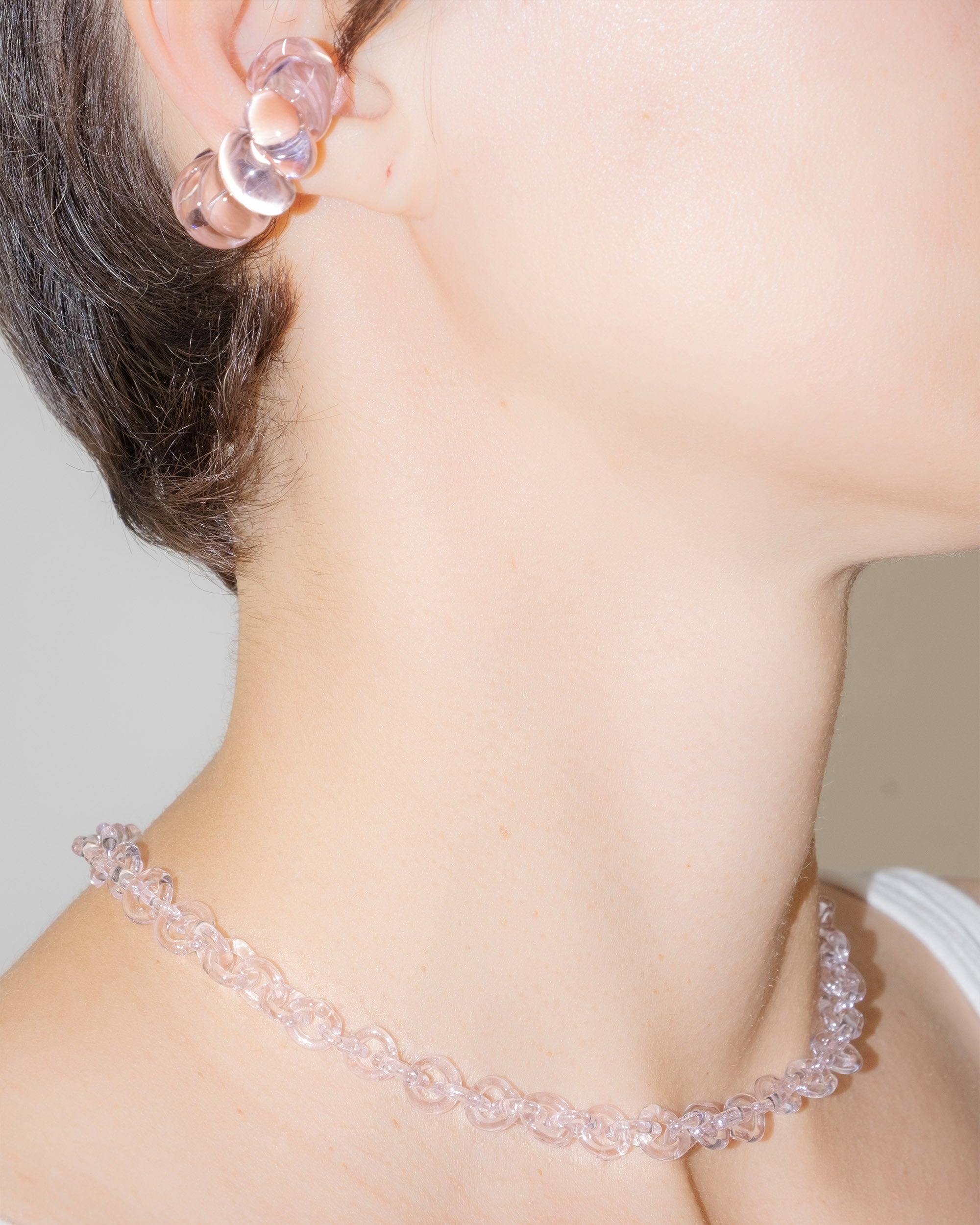 Model wearing pink glass chain necklace styled as a choker, handmade thin borosilicate links with sterling silver clasp.