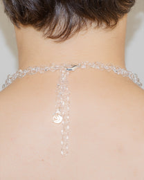 Model wearing thin transparent glass chain necklace with sterling silver clasp.