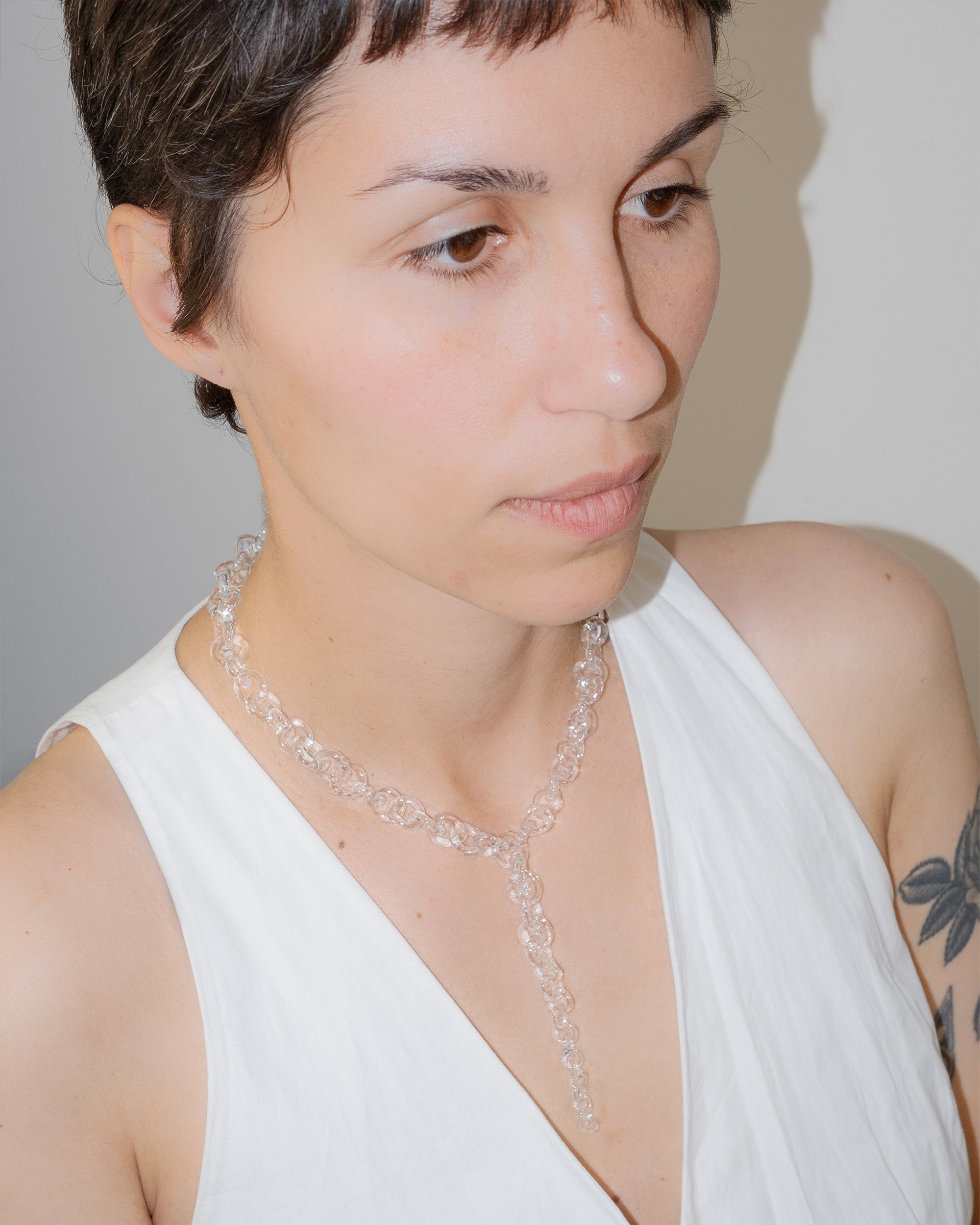 Model wearing bold transparent glass chain necklace with drop detail, handmade borosilicate links and sterling silver clasp.