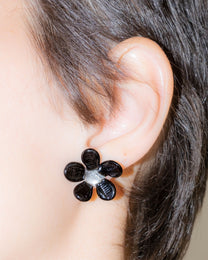 Model wearing Black Flower Stud Earrings, handmade borosilicate glass flower design on sterling silver studs.