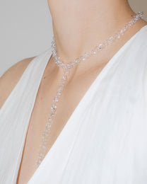 Model wearing thin transparent glass chain necklace with extended drop, styled elegantly, handmade borosilicate links with sterling silver clasp.