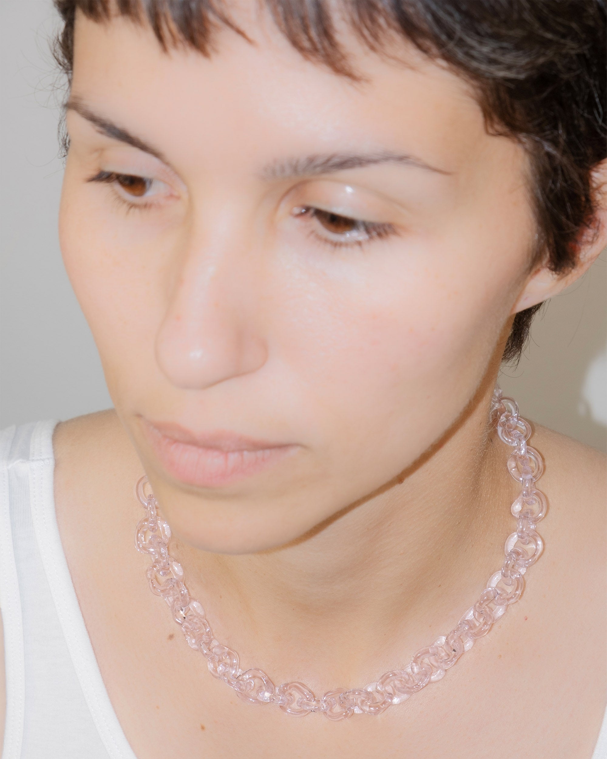 Model wearing bold glass chain necklace in pink, handmade borosilicate links with minimal, timeless design.