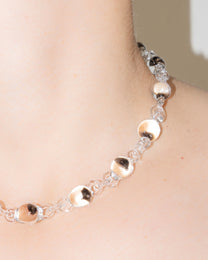 Model wearing Orb Mini Necklace with transparent glass spheres containing black-tinted fading accents, handmade borosilicate jewelry.