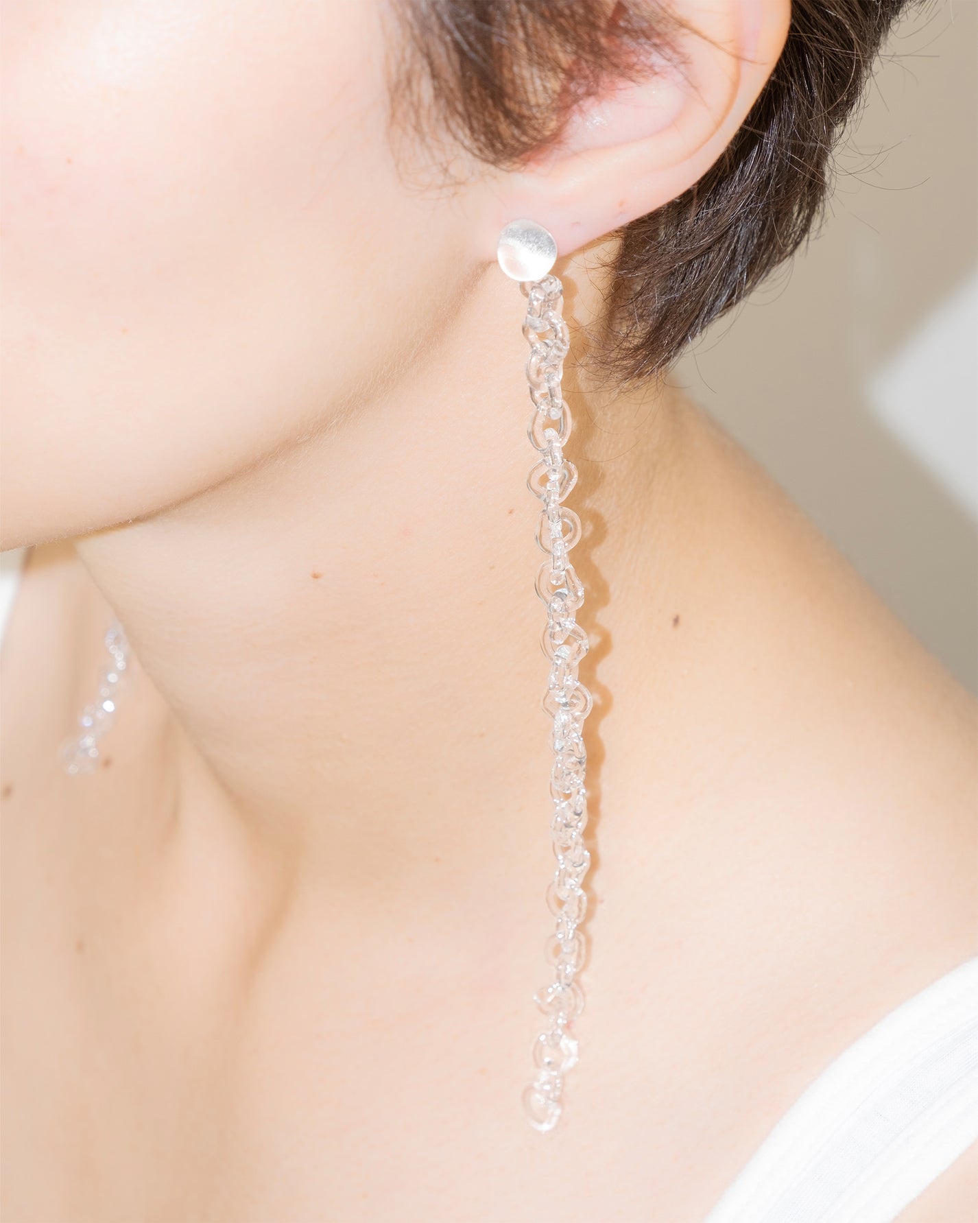 Model wearing Thin Chain Earrings, extra-long chain style handmade from borosilicate glass with orb top detail and sterling silver studs.