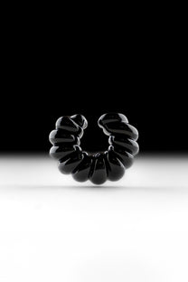 Black borosilicate glass ear cuff, shaped by hand into a continuous twist.