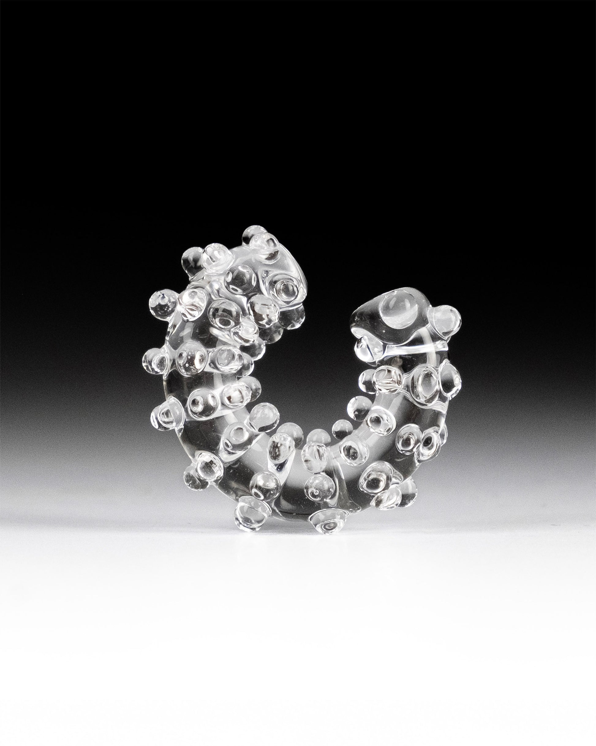 Handmade transparent borosilicate glass ear cuff, decorated with small spheres and dots, fits securely without a piercing.