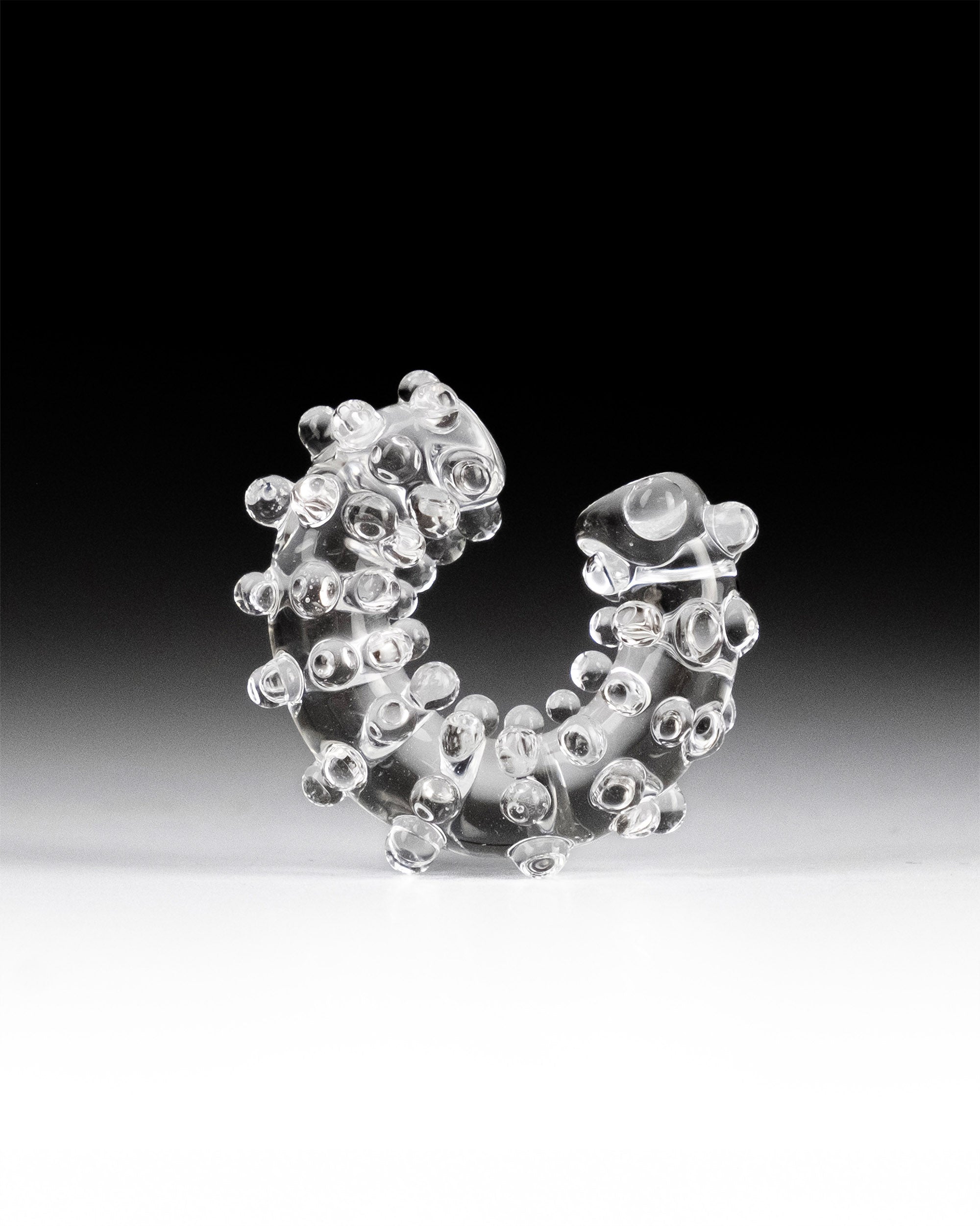 Handmade transparent borosilicate glass ear cuff, decorated with small spheres and dots, fits securely without a piercing.