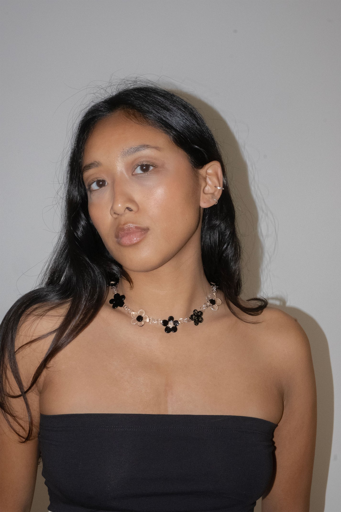 Handmade black glass flower necklace worn as a choker