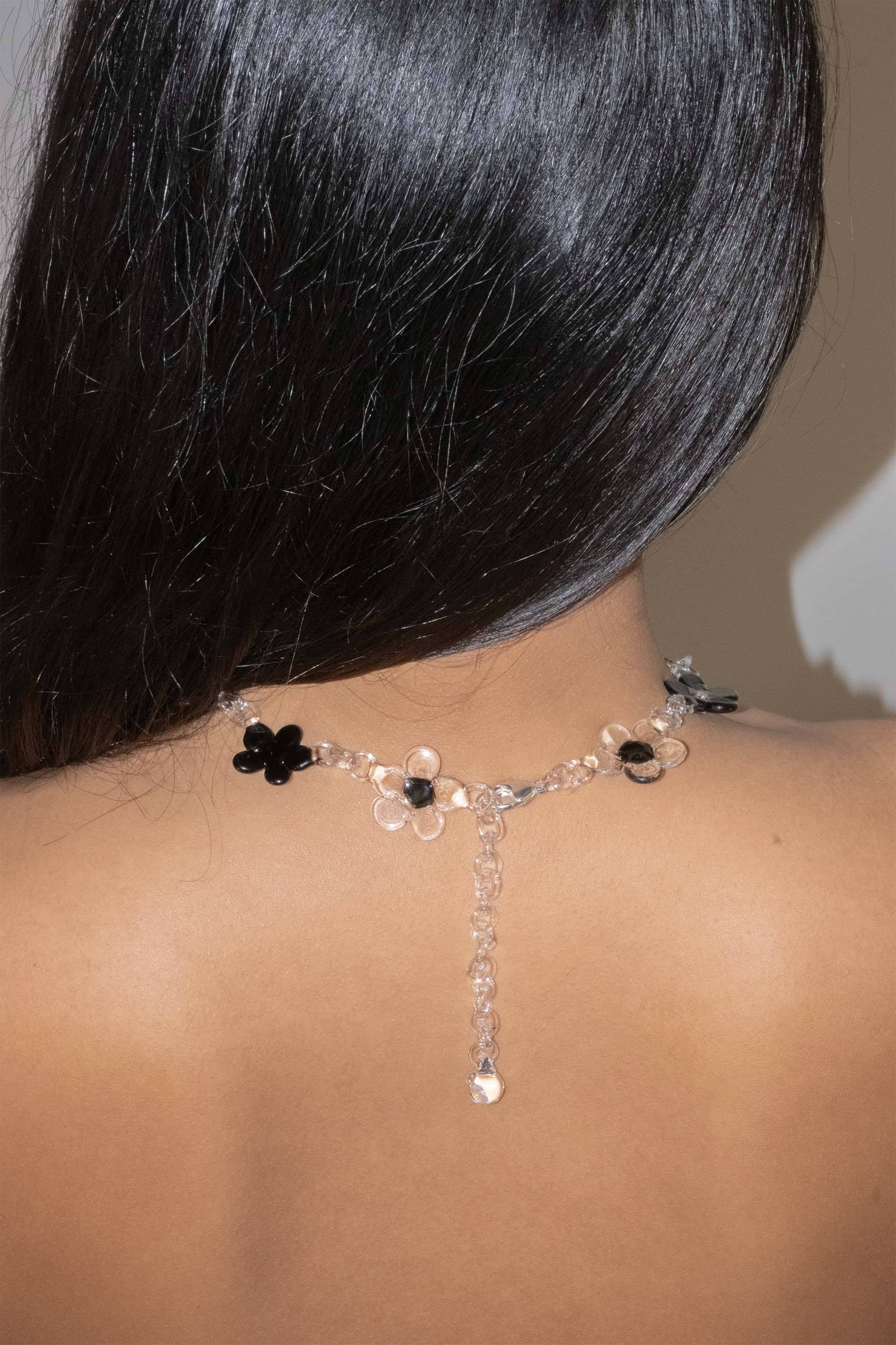 Handmade black glass flower necklace worn as a choker