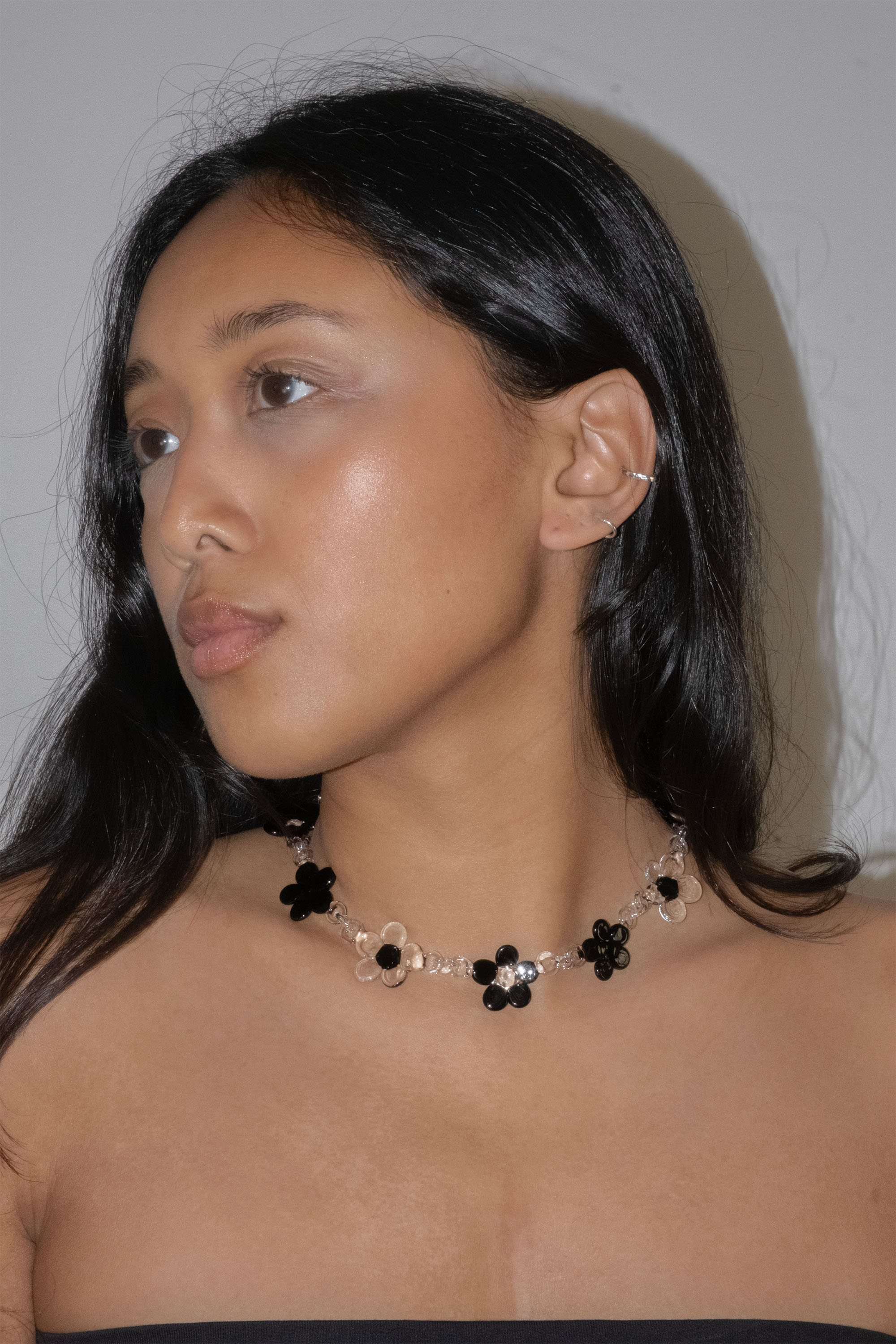 Handmade black glass flower necklace worn as a choker