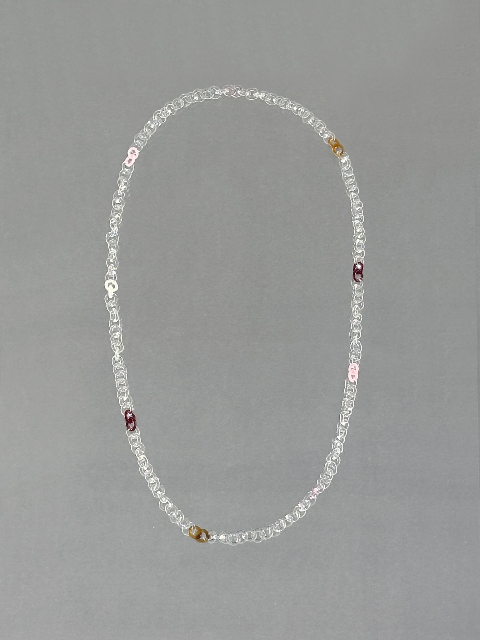 Unique handmade Sequence Necklace crafted from borosilicate glass in amber, red, pink, opaque pink, white and transparent tones.