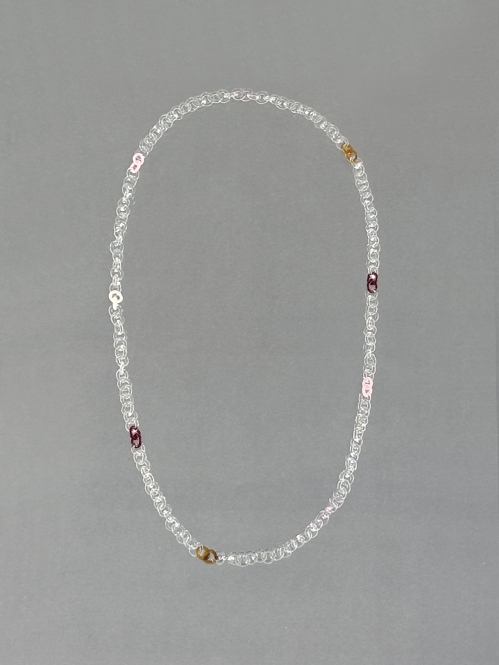 Unique handmade Sequence Necklace crafted from borosilicate glass in amber, red, pink, opaque pink, white and transparent tones.