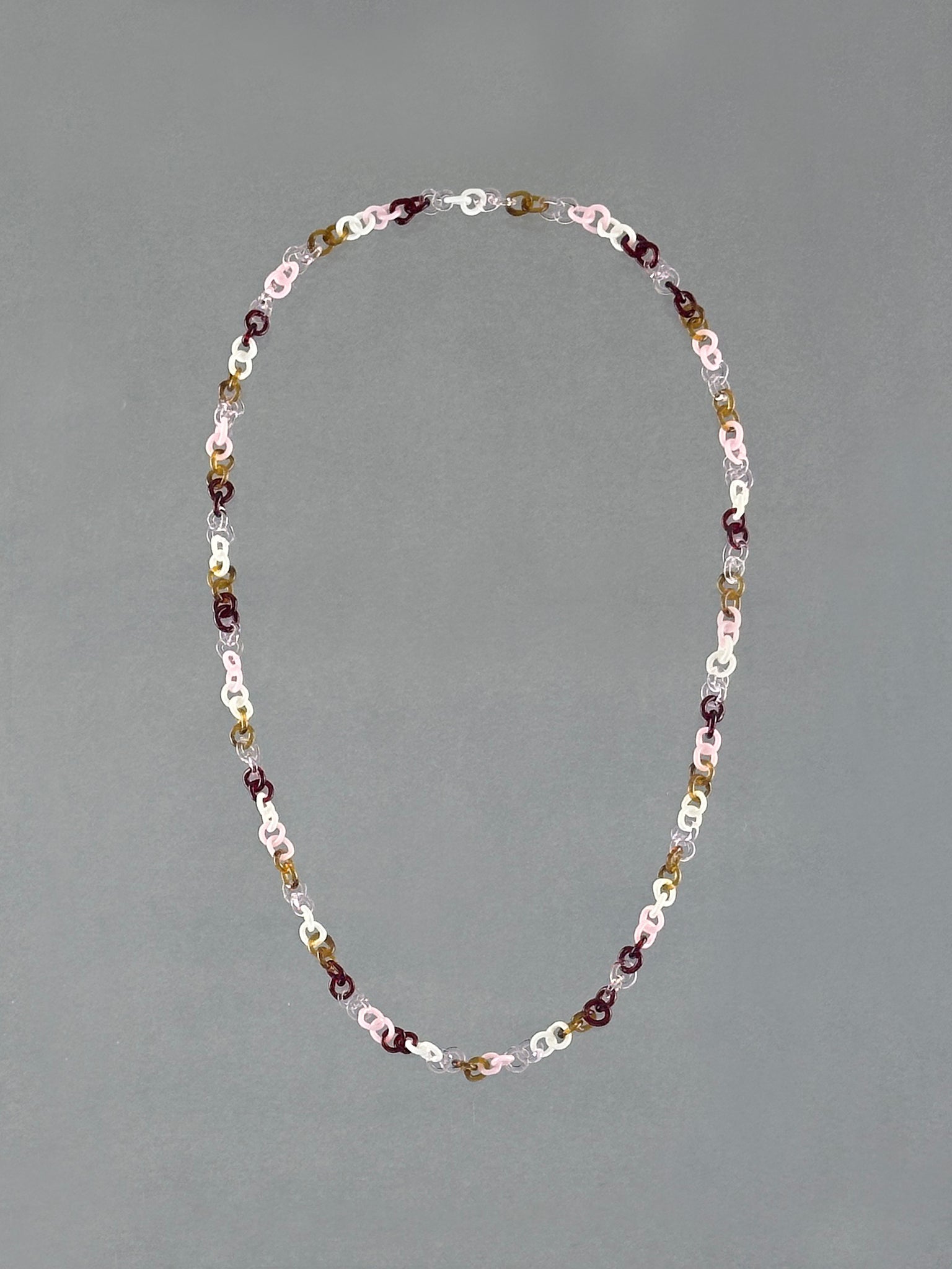 Handmade Sequence Necklace featuring a unique sequence of borosilicate glass links in amber, red, pink, white and transparent glass.