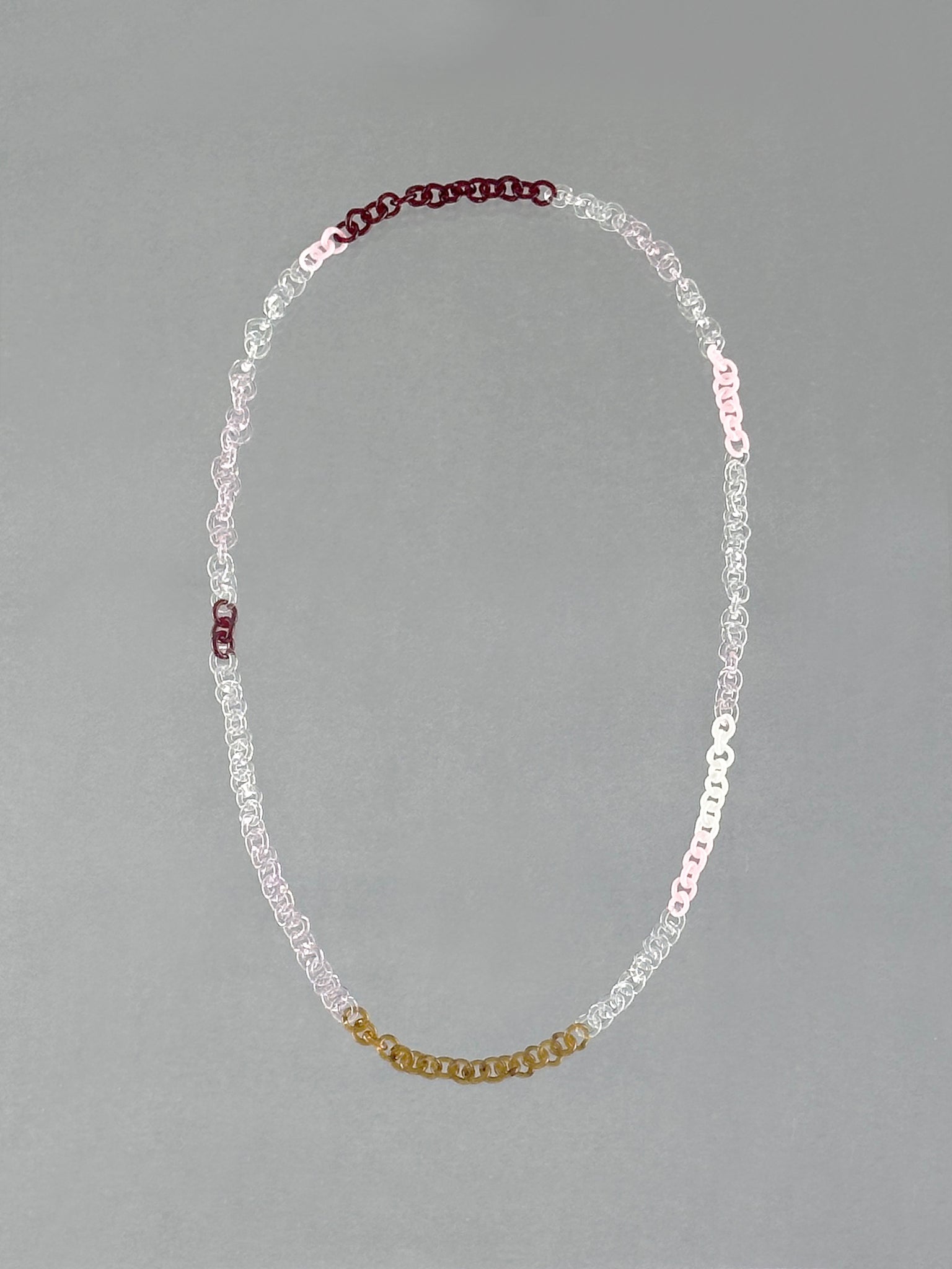 Handmade Sequence Necklace made from borosilicate glass links in amber, red, pink, opaque pink, white and transparent glass.